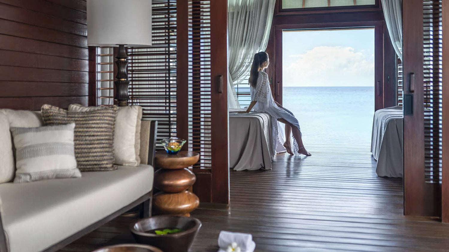 Four Seasons Resort Maldives at Landaa Giraavaru. A woman in villa looking out at the sea. Teresa Tarmey super facialist residency at Four Seasons Resort Maldives