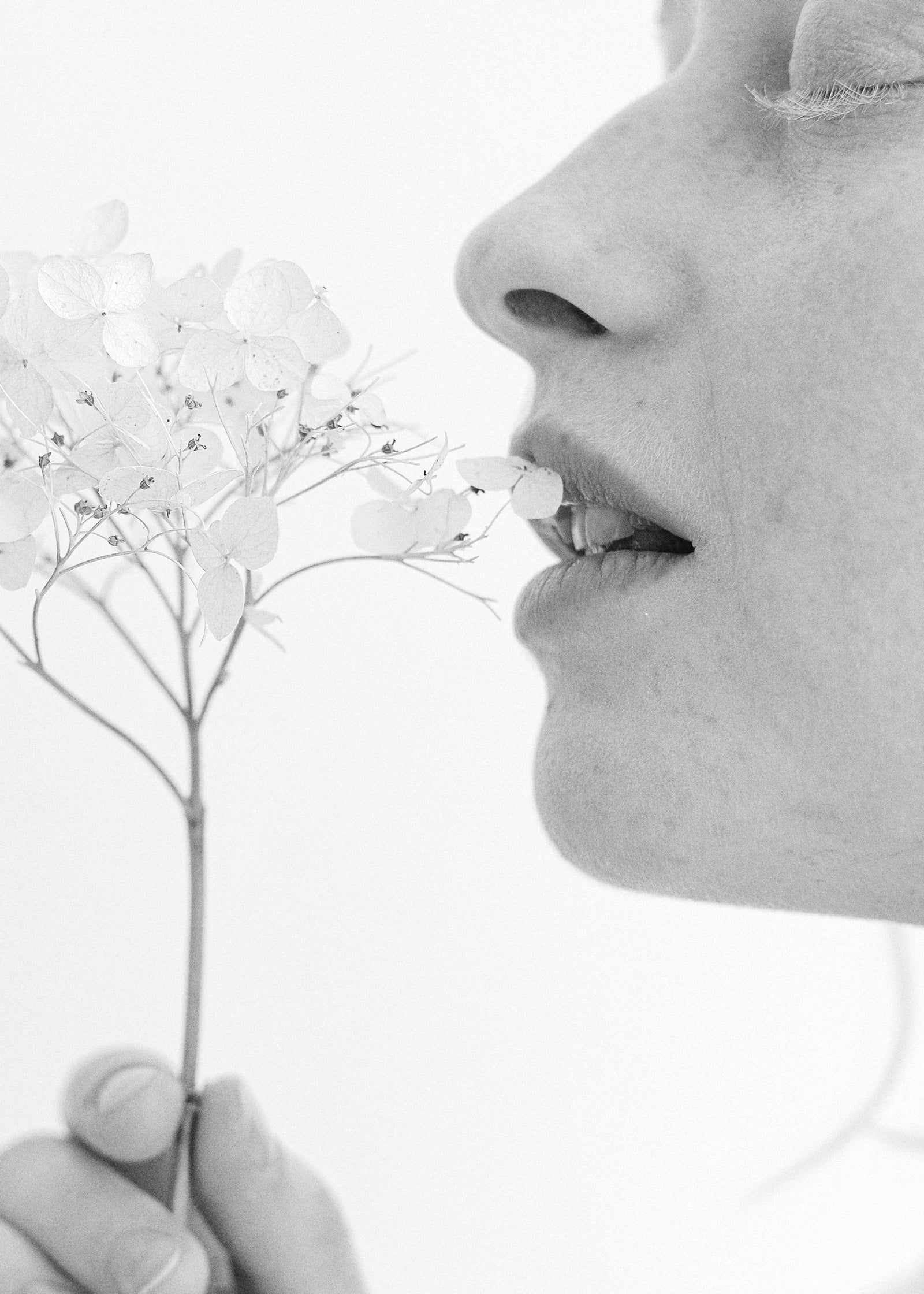 A woman with flowers by her lips. Lip Fillers - Aesthetic treatments at Teresa Tarmey skin care clinic