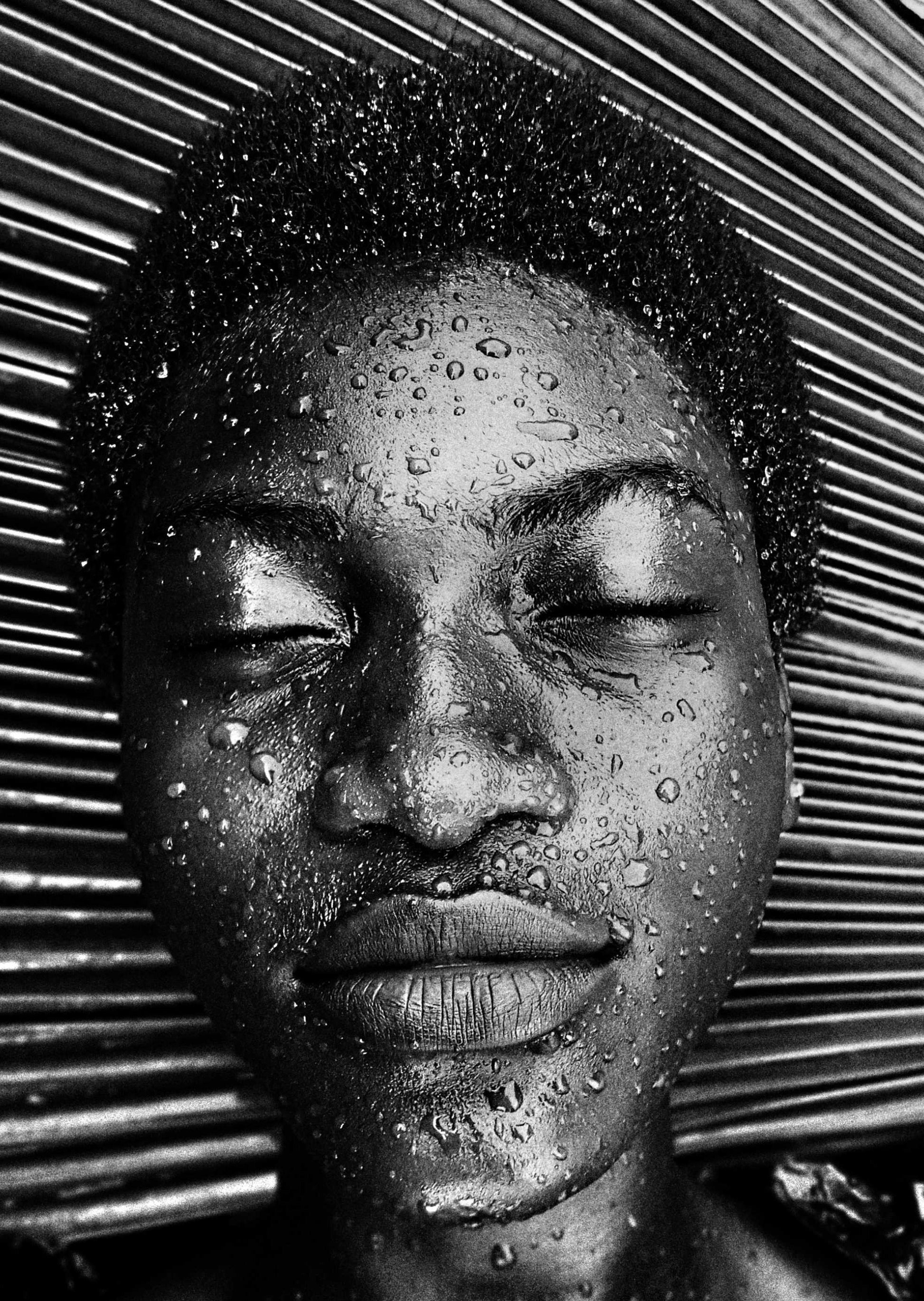 An arty photo of a Black woman with water droplets on her face. Advanced Facial.  Signature Facials at Teresa Tarmey